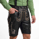 Black leather-like traditional shorts with embroidered floral and deer motifs, worn with a green gingham shirt against a white studio background.
