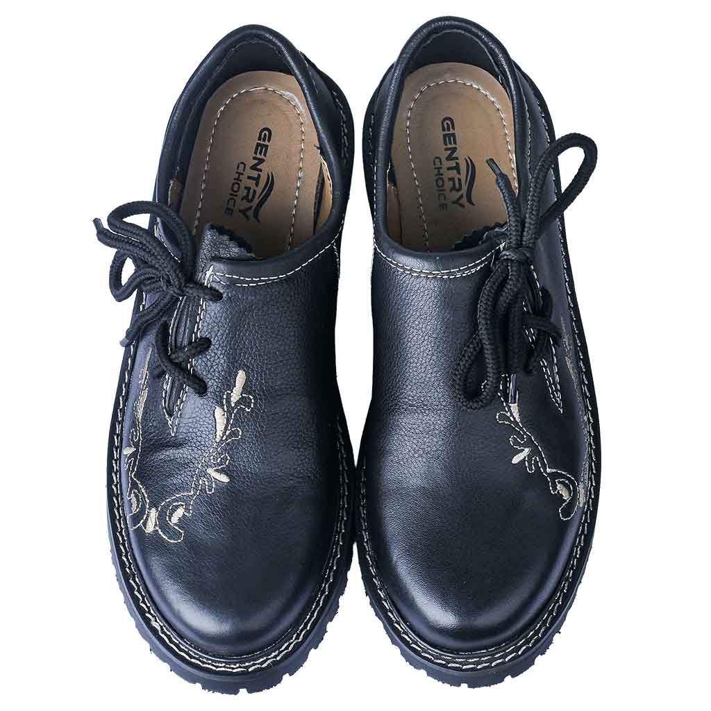 Pair of men's Oktoberfest shoes in black cowhide leather with tan embroidery, viewed from above