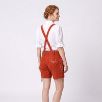 Model wearing Womens Red Suede Leather Lederhosen Oktoberfest Outfit showing crossed suspenders and embroidered heart back pocket