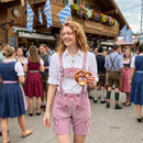 Woman wearing Womens Oktoberfest Outfit Lederhosen Suede Leather Oktoberfest Dress Rose Pink at Oktoberfest festival with embroidered suspenders