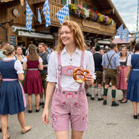 Woman wearing Womens Oktoberfest Outfit Lederhosen Suede Leather Oktoberfest Dress Rose Pink at Oktoberfest festival with embroidered suspenders