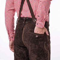 A person wearing dark brown Lederhosen suspenders and trousers, paired with a red and white gingham long-sleeve shirt, shown from the back against a white background.