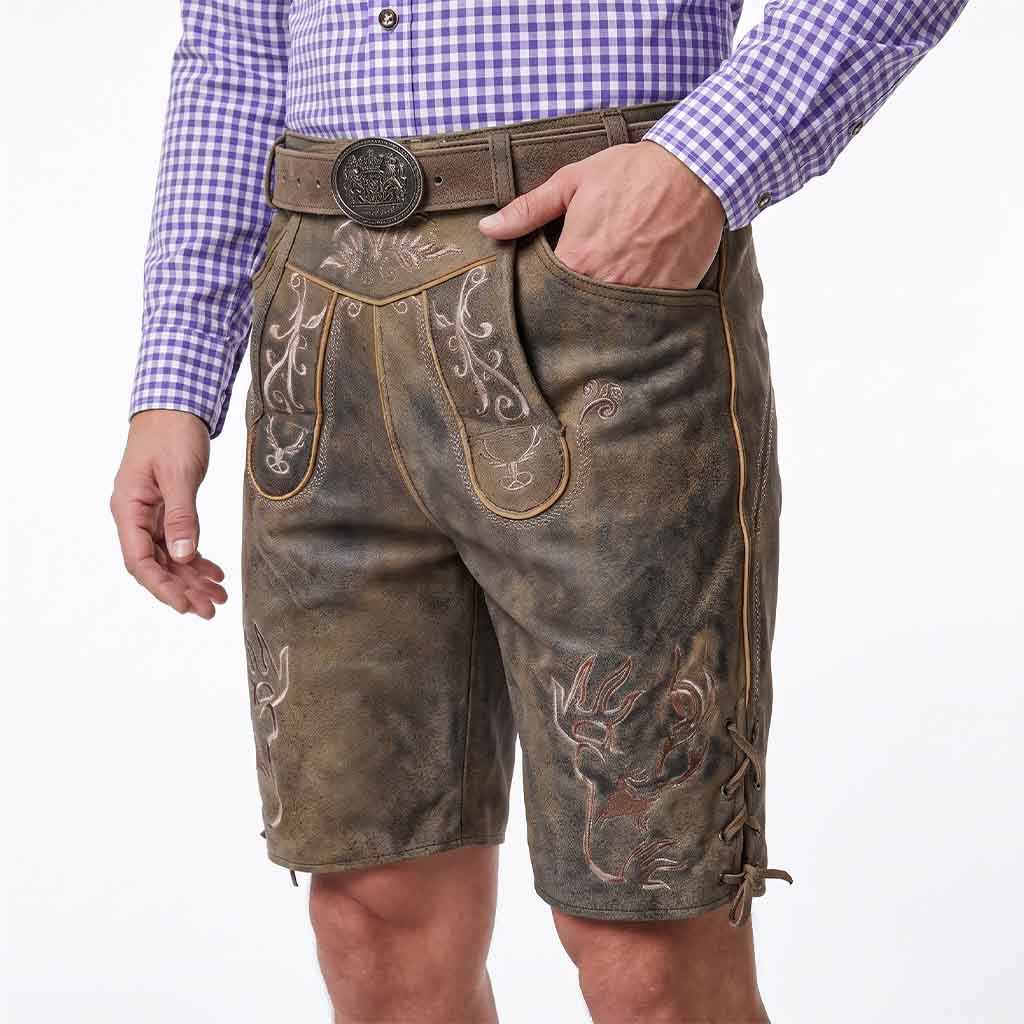 A man wearing distressed brown leather western-style shorts with embroidered details, a brown belt with a large round buckle, and a purple-and-white checkered shirt, shown from the waist down against a white background.