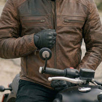 Close-up detail of RIDERACT leather motorcycle jacket zipper and front pocket design