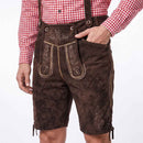 A person wearing dark brown suede lederhosen with embroidered details and suspenders, paired with a red and white gingham shirt, shown from the waist down against a white background.